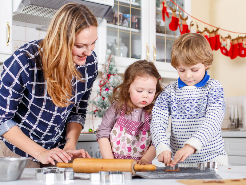 Mom baking christmas cookies with her kids