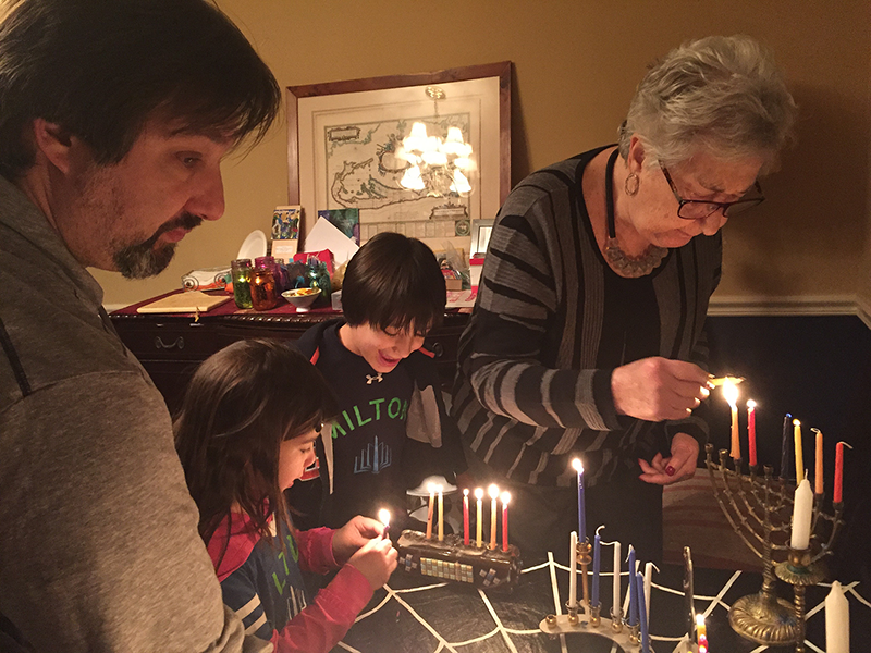 family lighting Menorahs