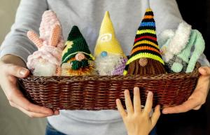 Knitted gnomes in the hands of a needlewoman. Home decoration, soft toy. Easter decor. Kids toys.