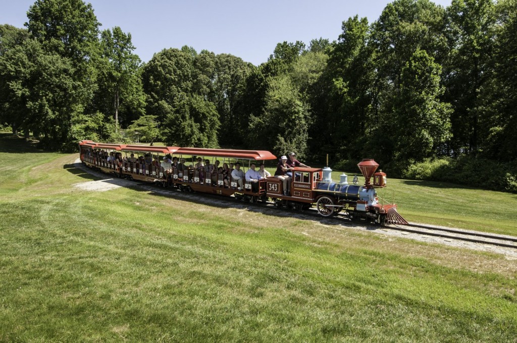 A red open Burke Lake Park Miniature Train with kids