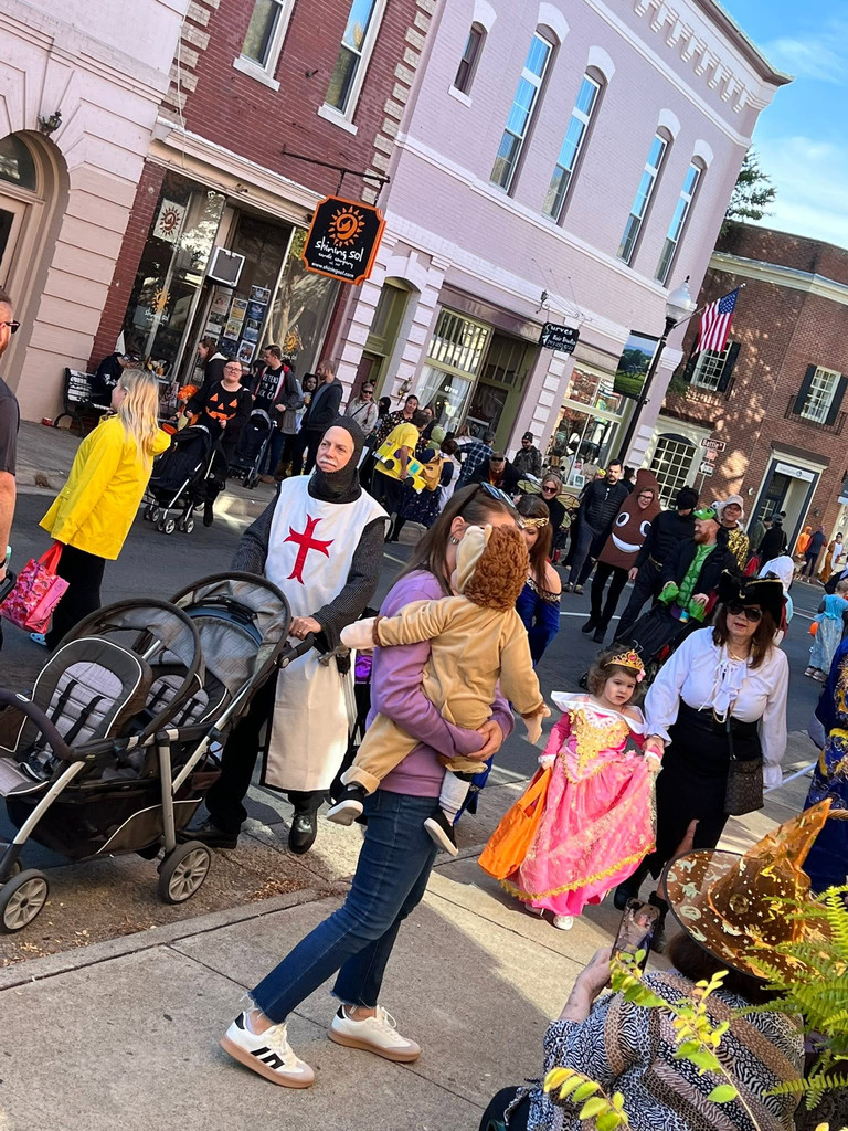 A family dressed as Ghostbusters pushes a stroller through Historic Downtown Manassas during Haunted Happenings