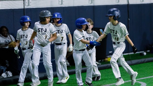 Young baseball player at bat during a clinic drill in the DMV area