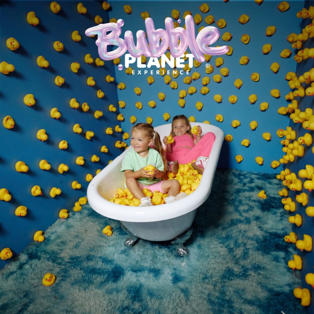 Two children sit in a bathtub surrounded by yellow rubber ducks at Bubble Planet DC