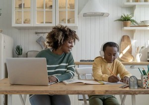 A mother checking his son's progress on a school homework while working at home. Photo credit: DimaBerlin // Shutterstock