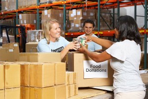 Thanksgiving volunteers sorting canned food donations in a warehouse