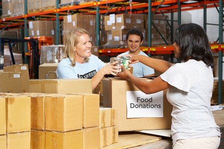 Thanksgiving volunteers sorting canned food donations in a warehouse