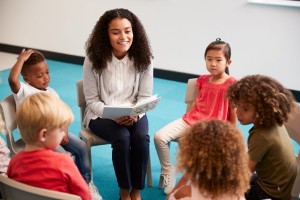 A teacher reads aloud to a circle of young children, the kind of story time where books about bullying for kids can start a conversation